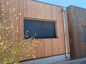 bardage ossature bois avec une ouverture anthracite atelier bois concept loïc chambru